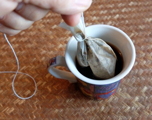 Making a coffee bag with a paper filter and string.